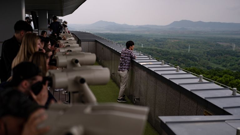 Tourists use binoculars to view North Korea from the Dora...