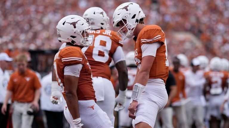 Texas wide receiver DeAndre Moore Jr., left, celebrates his touchdown...