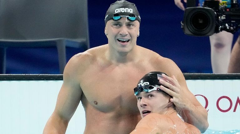 Nicolo Martinenghi, of Italy, top, is congratulated by Nic Fink,...