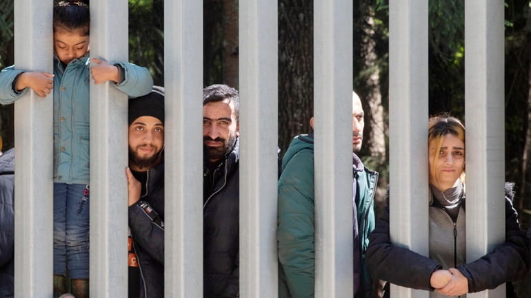 Members of a group of some 30 migrants seeking asylum...