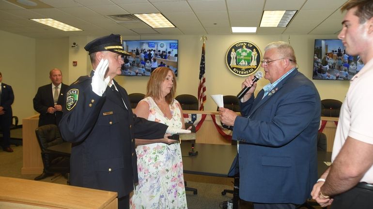 Riverhead Town Supervisor Tim Hubbard swears in the new police chief,...