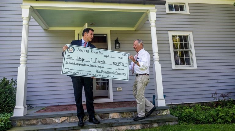 Rep. Thomas Suozzi (D-Glen Cove) on Thursday presents symbolic checks representing...