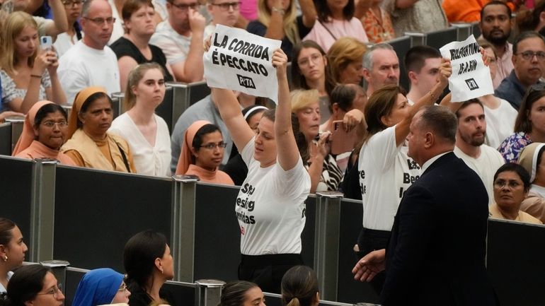 Protesters wear t-shirts reading: "stop blessing corridas" as they hold...