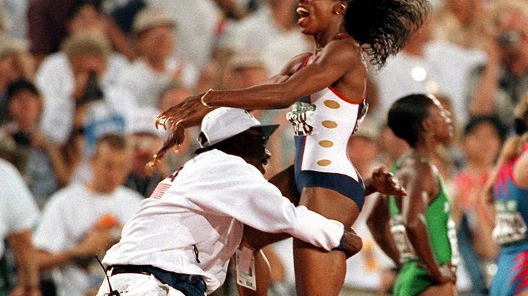 Gail Devers of the United States jumps into the arms...