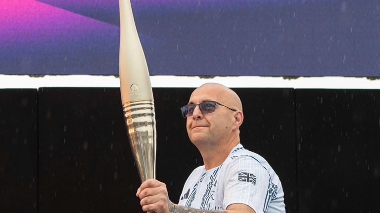 British Paralympian Gregor Ewan holds the Paralympic Torch during the...