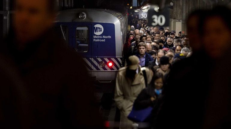 People disembark from a Metro-North train at Grand Central Terminal...