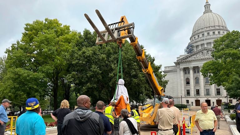 Workers lower a statue of Vel Phillips, Wisconsin's first Black...