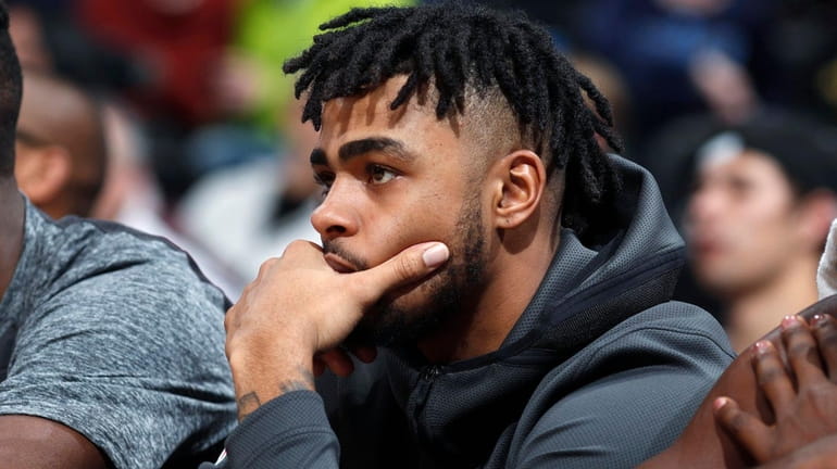 Nets guard D'Angelo Russell watches from the bench during the...