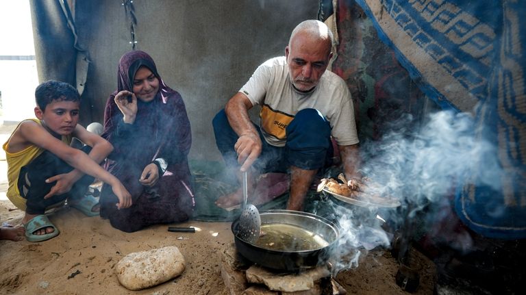 Hassan Nofal, right, who was displaced by the Israeli bombardment...