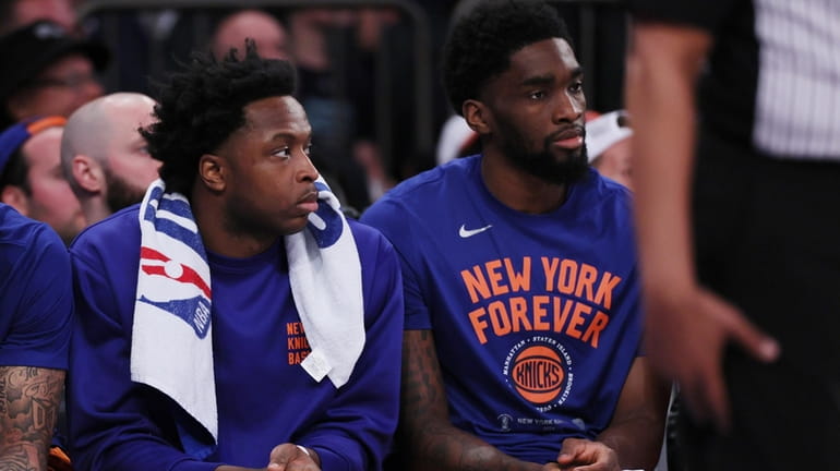 Knicks forward OG Anunoby, left, sits on the bench in the...