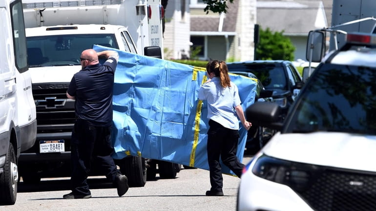 Police carry an object out of Rex Heuermann's house on...