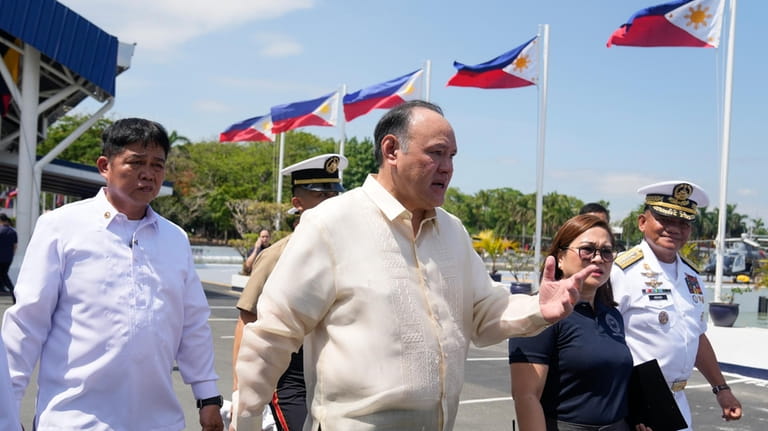 Philippine Defense Secretary Gilberto Teodoro, center, walks with his staff...