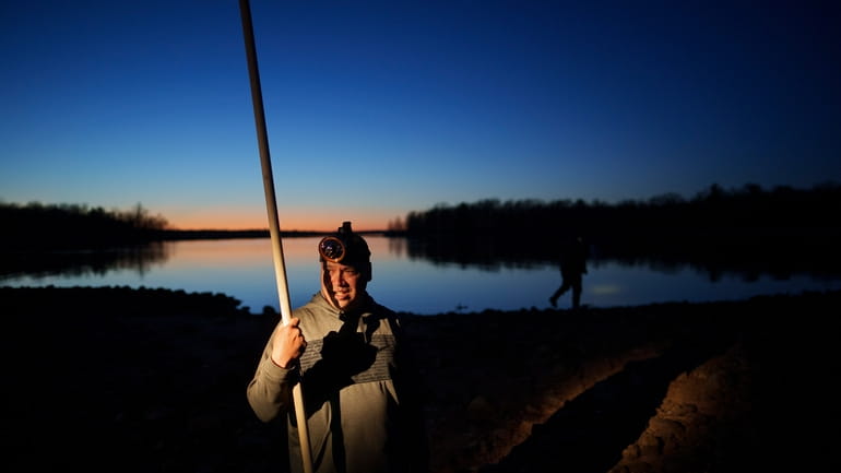 John Baker holds a spear while getting ready for a...