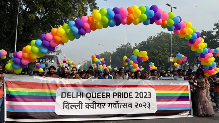 Participants of the Delhi Queer Pride Parade carry a banner...