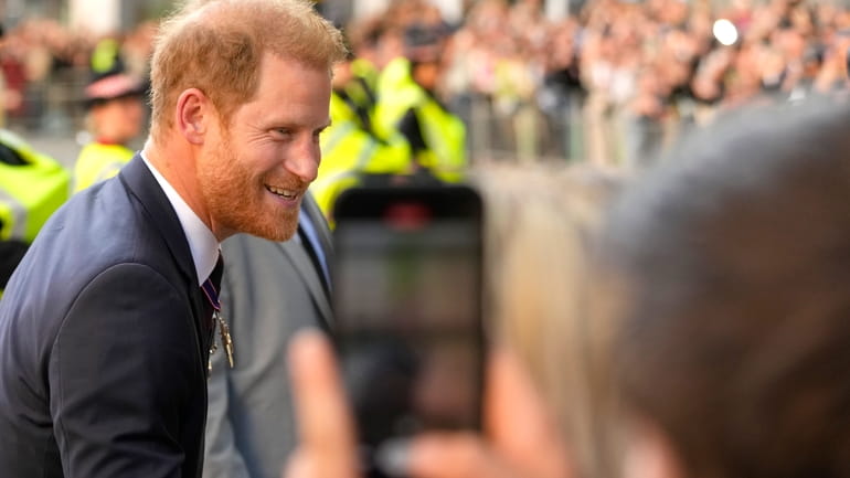 Britain's Prince Harry meets the crowd as he leaves after...