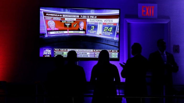 Supporters check early vote results during then-candidate Donald Trump's election...