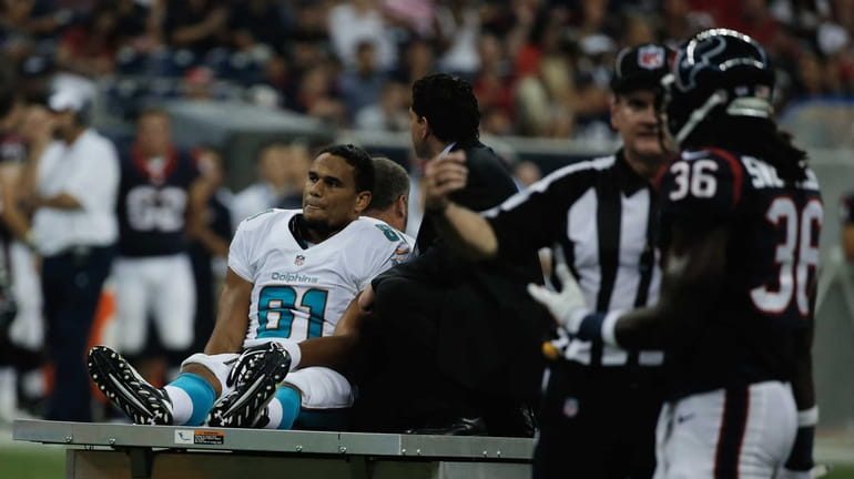 Dustin Keller of the Miami Dolphins is carted off the...