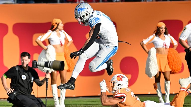 Detroit Lions wide receiver Amon-Ra St. Brown (14) avoids the...