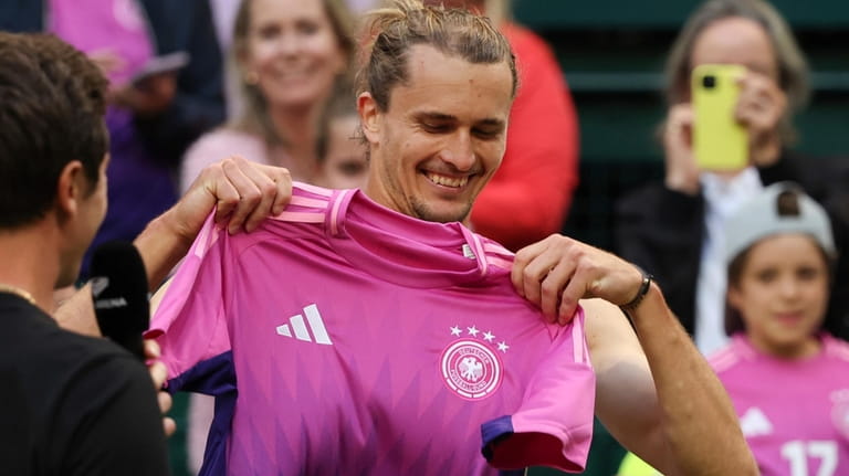 Germany's Alexander Zverev puts on a shirt of the German...