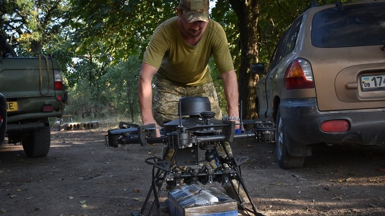 A soldier of Ukraine's 141st separate infantry brigade loads a...