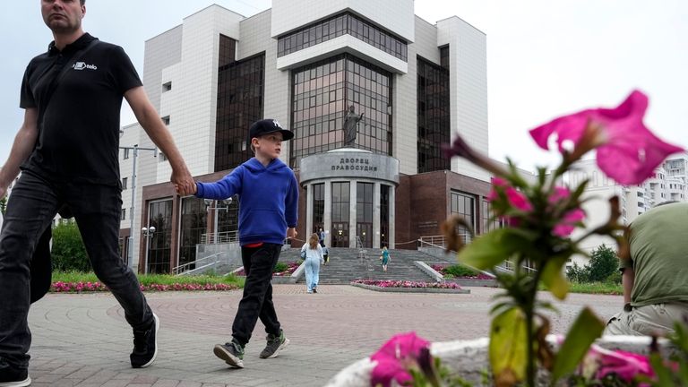 People walk past the court building with the words reading,...