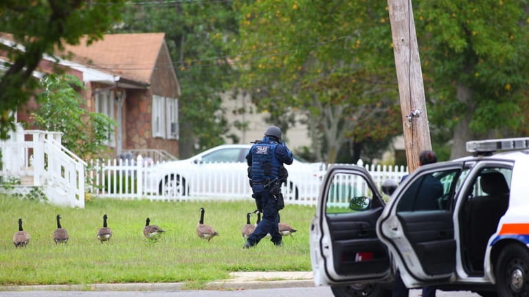 A police officer outside a home in East Massapequa near...