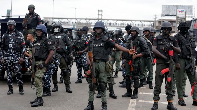 Police officers stand guard during a protest in Lagos, Nigeria,...