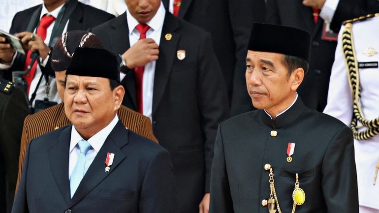 Indonesian outgoing President Joko Widodo, right, walks with Defense Minister...