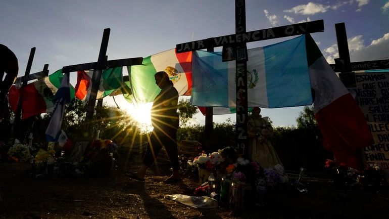 Mourners visit a make-shift memorial to honor the victims and...