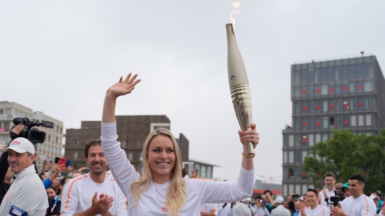 Former US skier Lindsey Vonn carries the Olympic torch in...