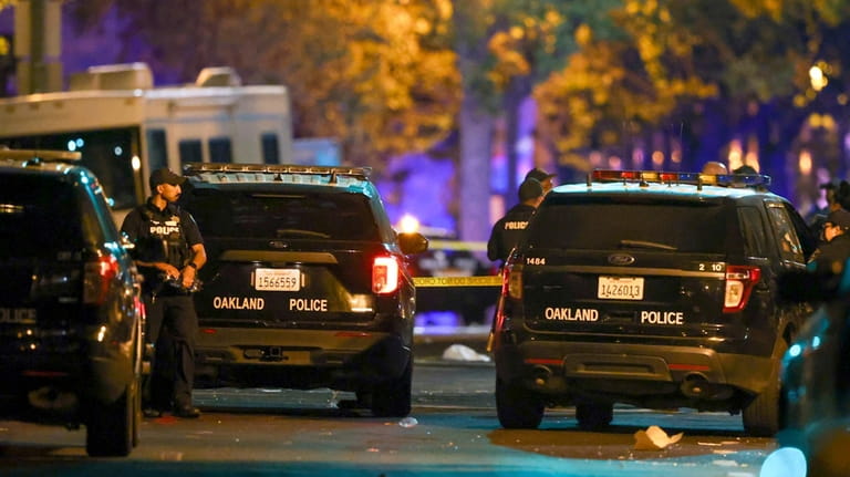 Oakland police officers respond to a multiple shooting during a...
