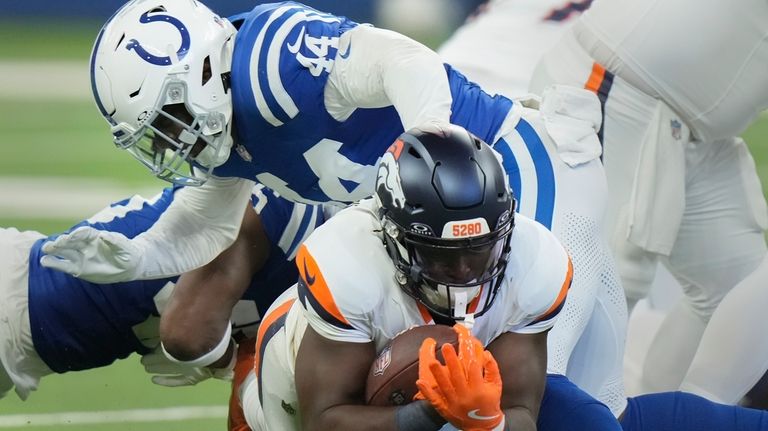 Denver Broncos running back Javonte Williams (33) is tackled by...