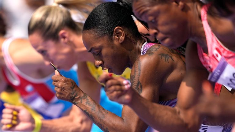 Sha'carri Richardson, of the United States, center, competes in her...