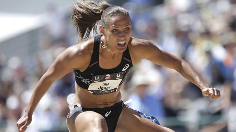 Lolo Jones, clears a hurdle in a semifinal heat of...