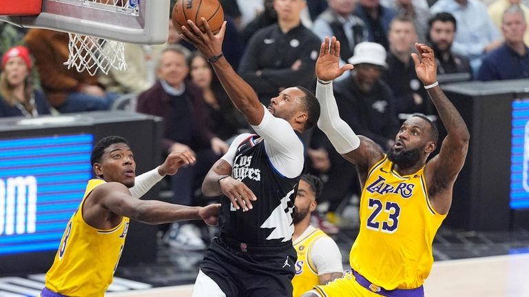 Los Angeles Clippers guard Norman Powell, center, shoots as Los...