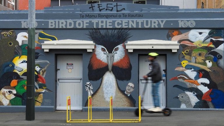 A man rides past a mural celebrating John Oliver's New...