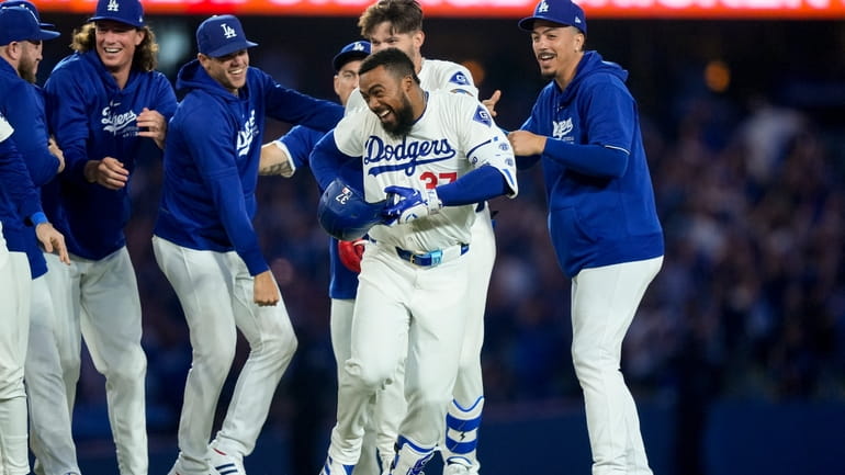 Los Angeles Dodgers' Teoscar Hernandez, center, celebrates with teammates after...