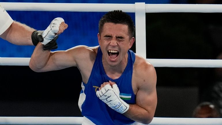 Uzbekistan's Hasanboy Dusmatov reacts after defeating France's Billal Bennama in...