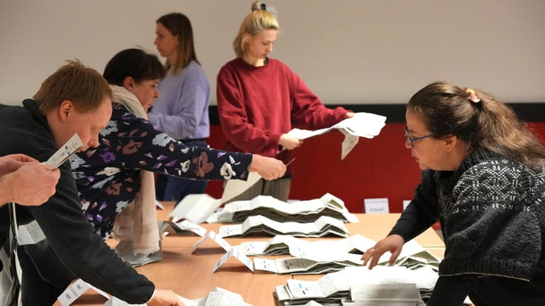 Poll workers sort the ballot papers during the vote count...