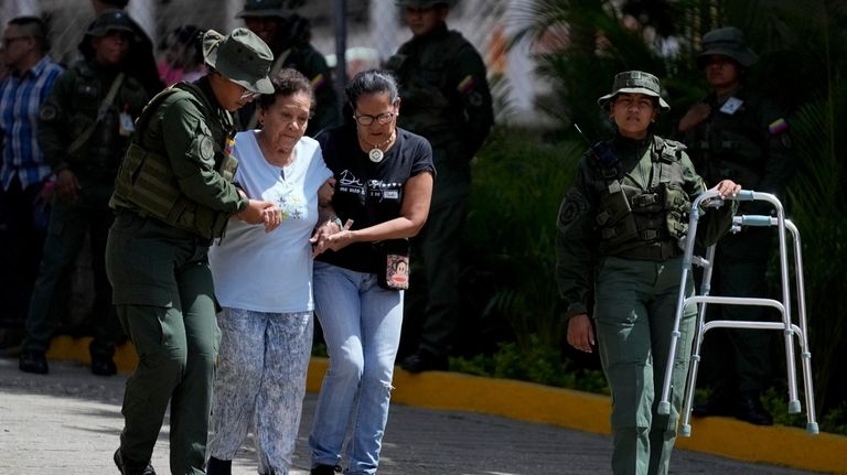 Military personnel help assist an elderly voter during the presidential...