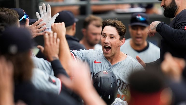 Minnesota Twins' Brooks Lee, center, celebrates with teammates in the...