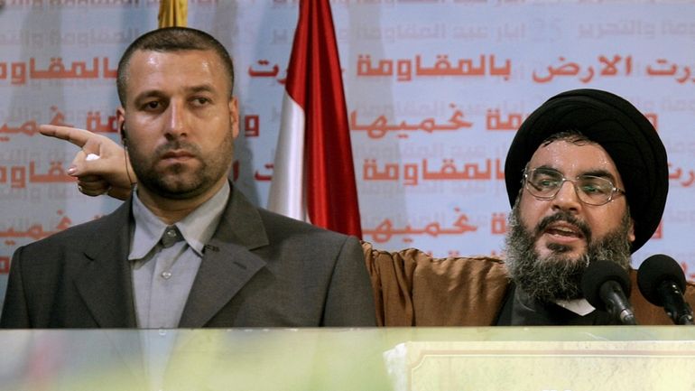 Hezbollah leader Sayyed Hassan Nasrallah, right, gives an address while...