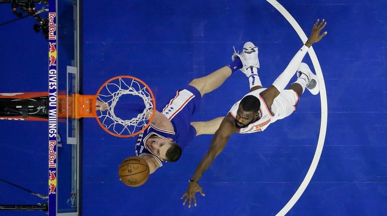 The 76ers' Mike Muscala goes up for a shot against...