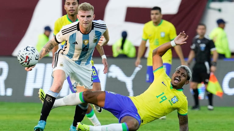 Brazil's John Kennedy, bottom, falls challenged by Argentina's Nicolas Valentini...