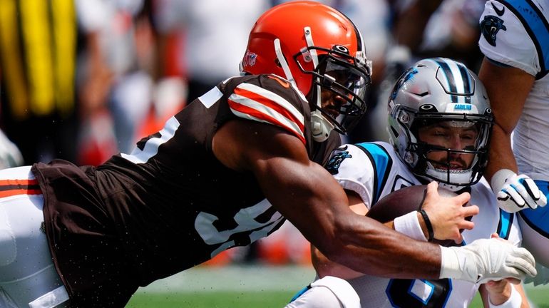 Carolina Panthers quarterback Baker Mayfield is tackled by Cleveland Browns...