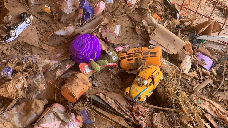 Toys are scattered outside a damaged house in Derna, Libya,...