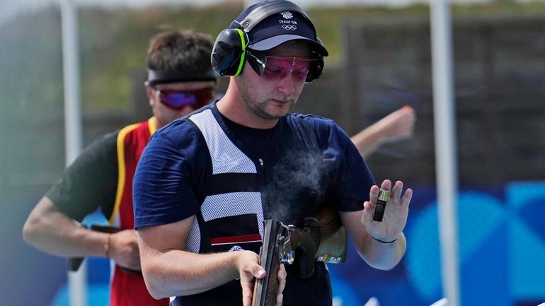 Britain's Nathan Hales ejects an empty cartridge from his shotgun...