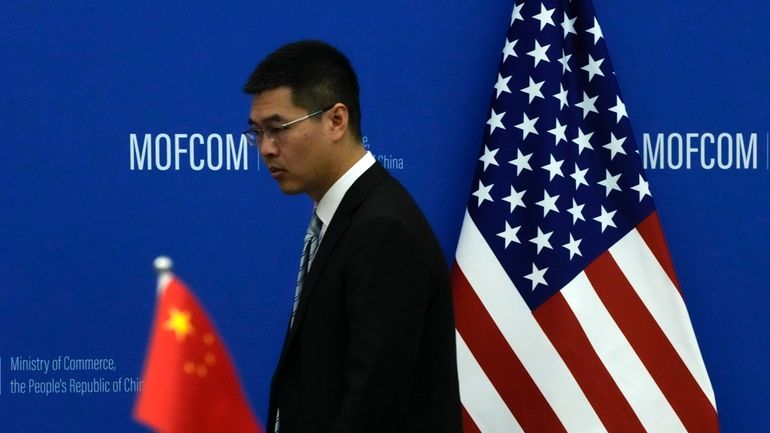 A Chinese official walks by the China and U.S. national...