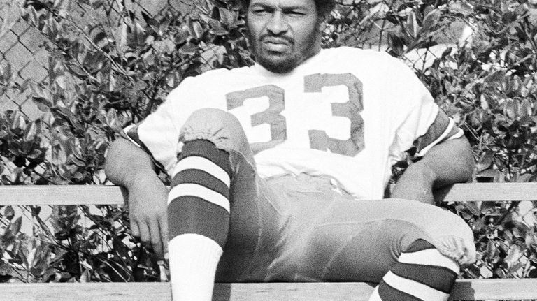 Dallas Cowboy running back Duane Thomas sits alone on bleachers...