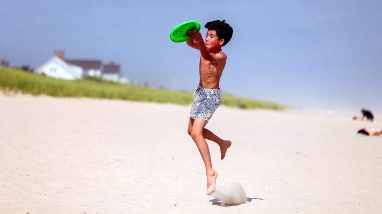 Kurt Heyn Jr., 12, plays frisbee at Coopers Beach in Southampton,...